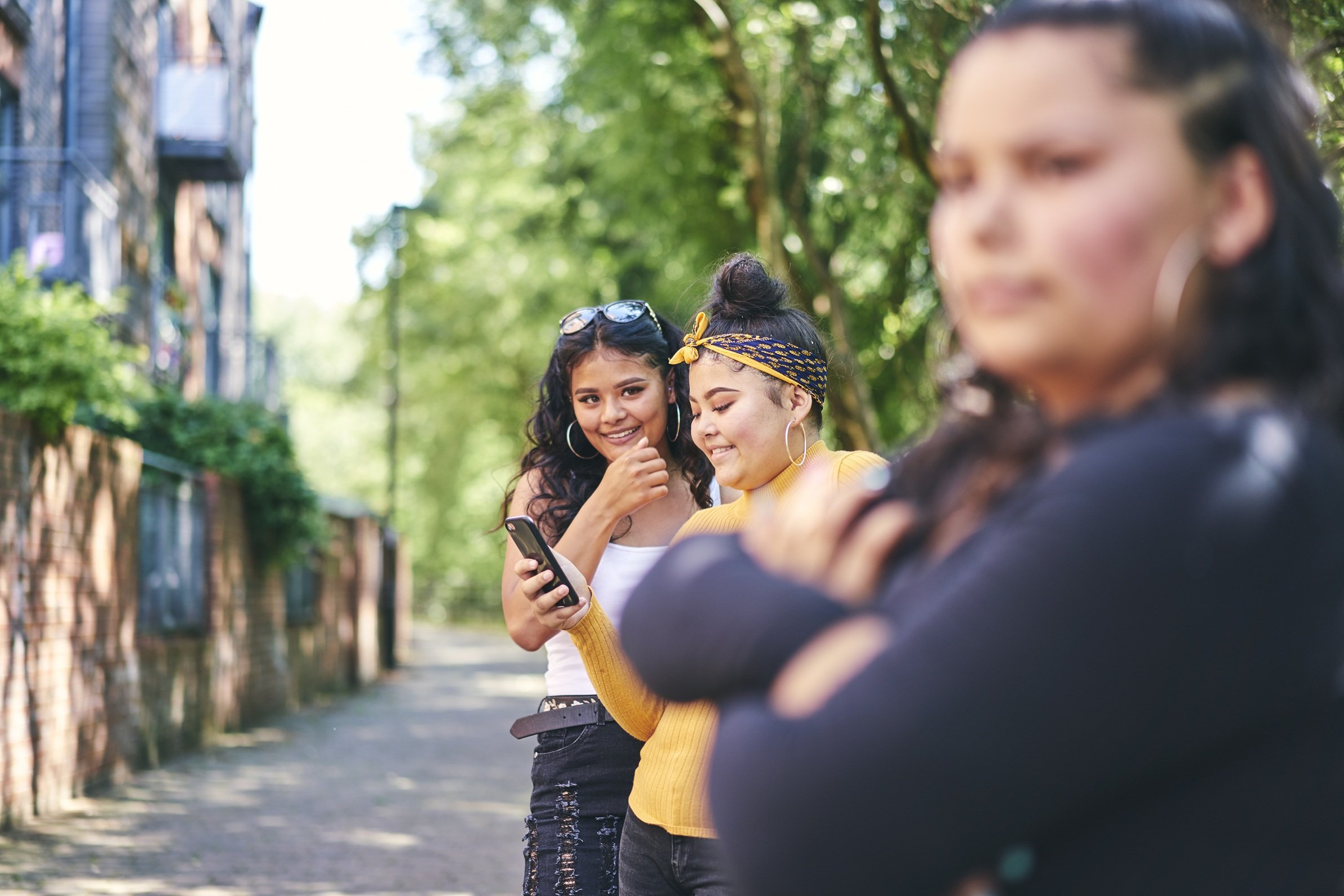 friends-smiling-and-looking-at-a-cellphone-outside-2026-03-25-04-46-51-utc