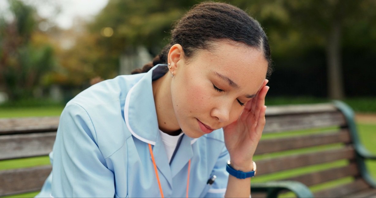 headache-tired-and-nurse-with-woman-on-park-bench-2026-03-25-02-14-58-utc