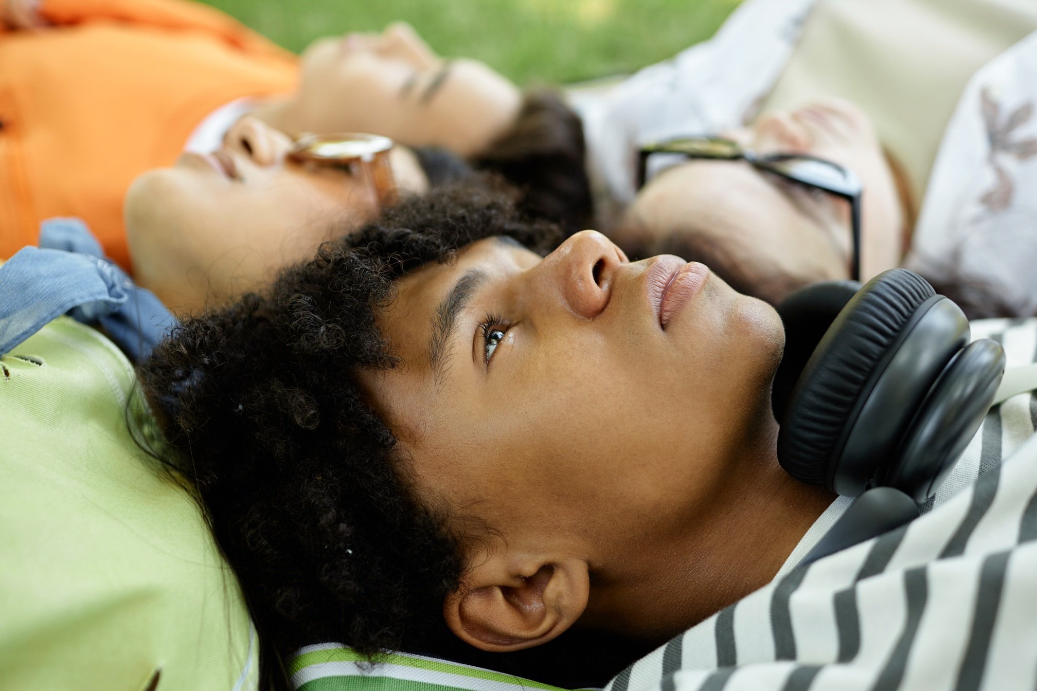 portrait-of-black-boy-lying-on-grass-with-friends-2026-01-08-06-55-38-utc