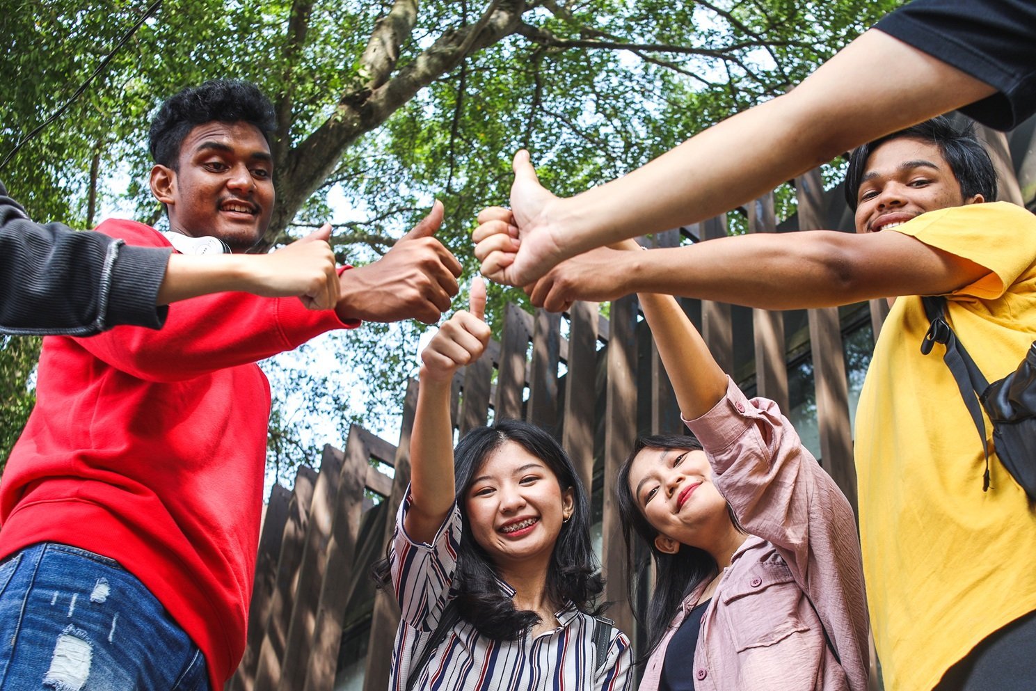 smiling-young-adults-giving-thumbs-up-in-urban-set-2026-01-07-06-41-52-utc