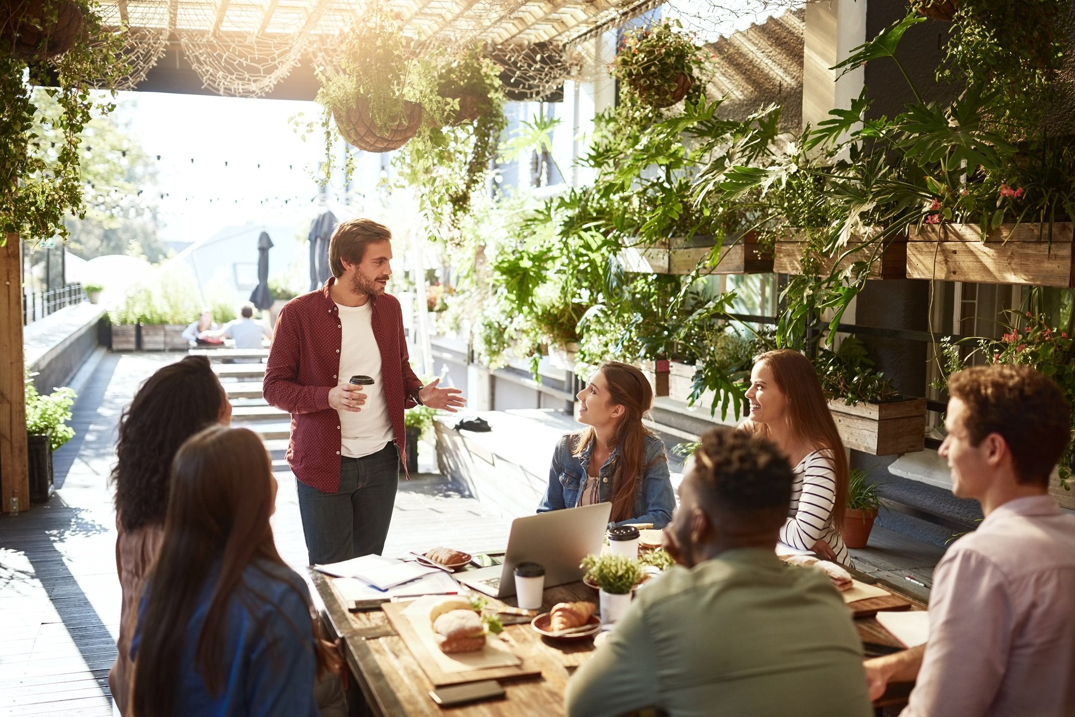 team-meeting-at-outdoor-cafe-with-lush-greenery-2026-01-09-09-14-28-utc