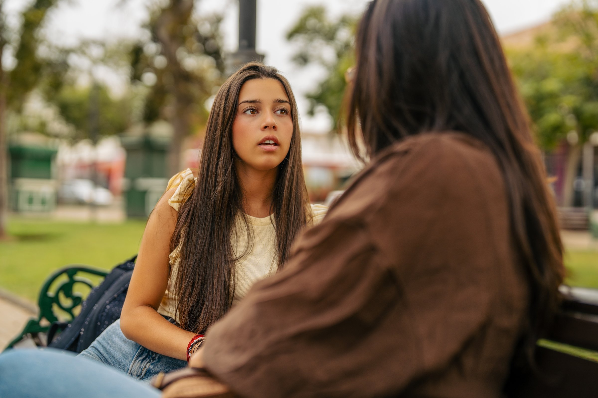 two-teens-chatting-on-park-bench-together-2026-04-08-04-58-47-utc