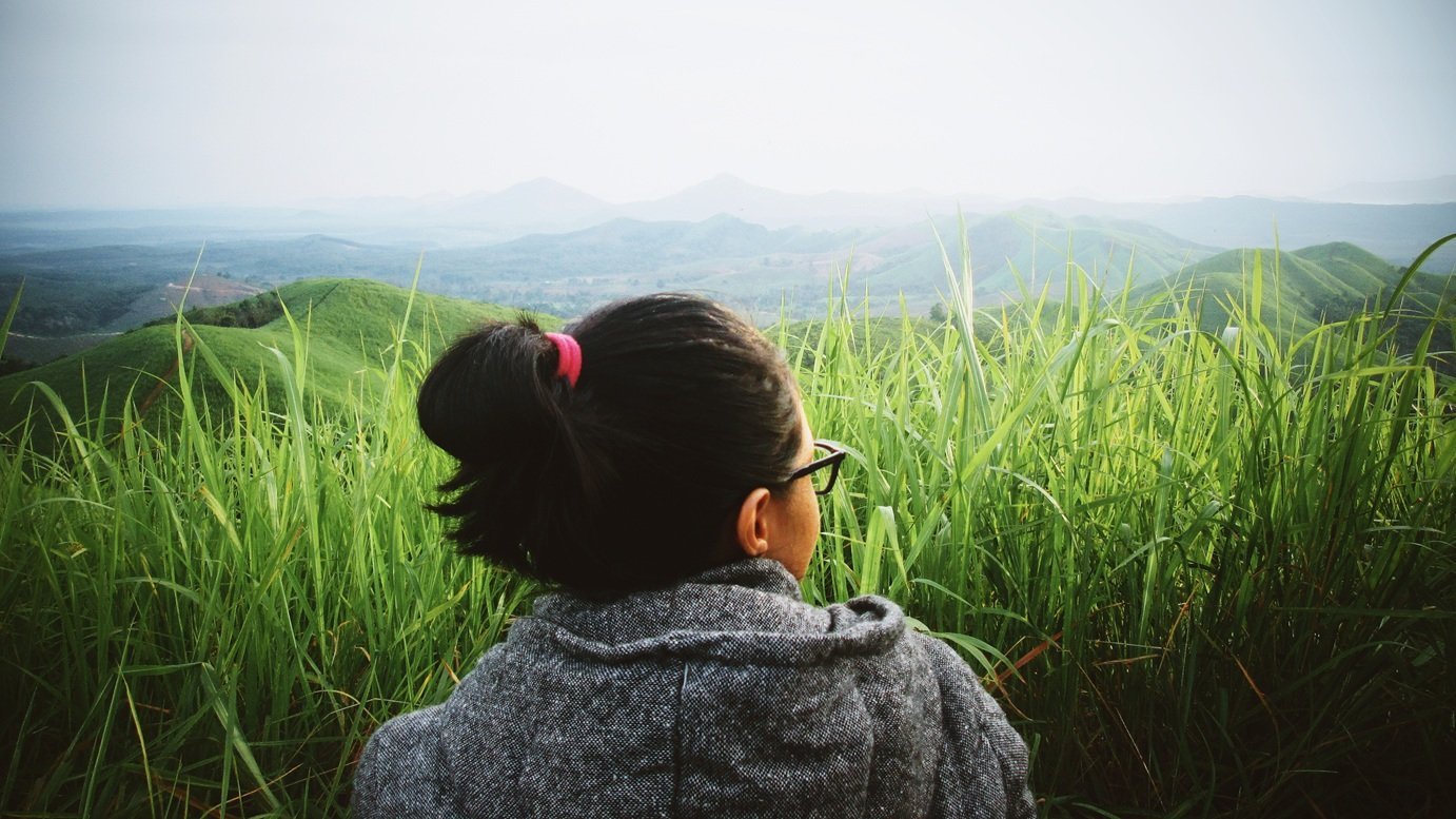 woman-enjoys-the-view-from-grassy-hillside-2026-03-17-17-14-18-utc