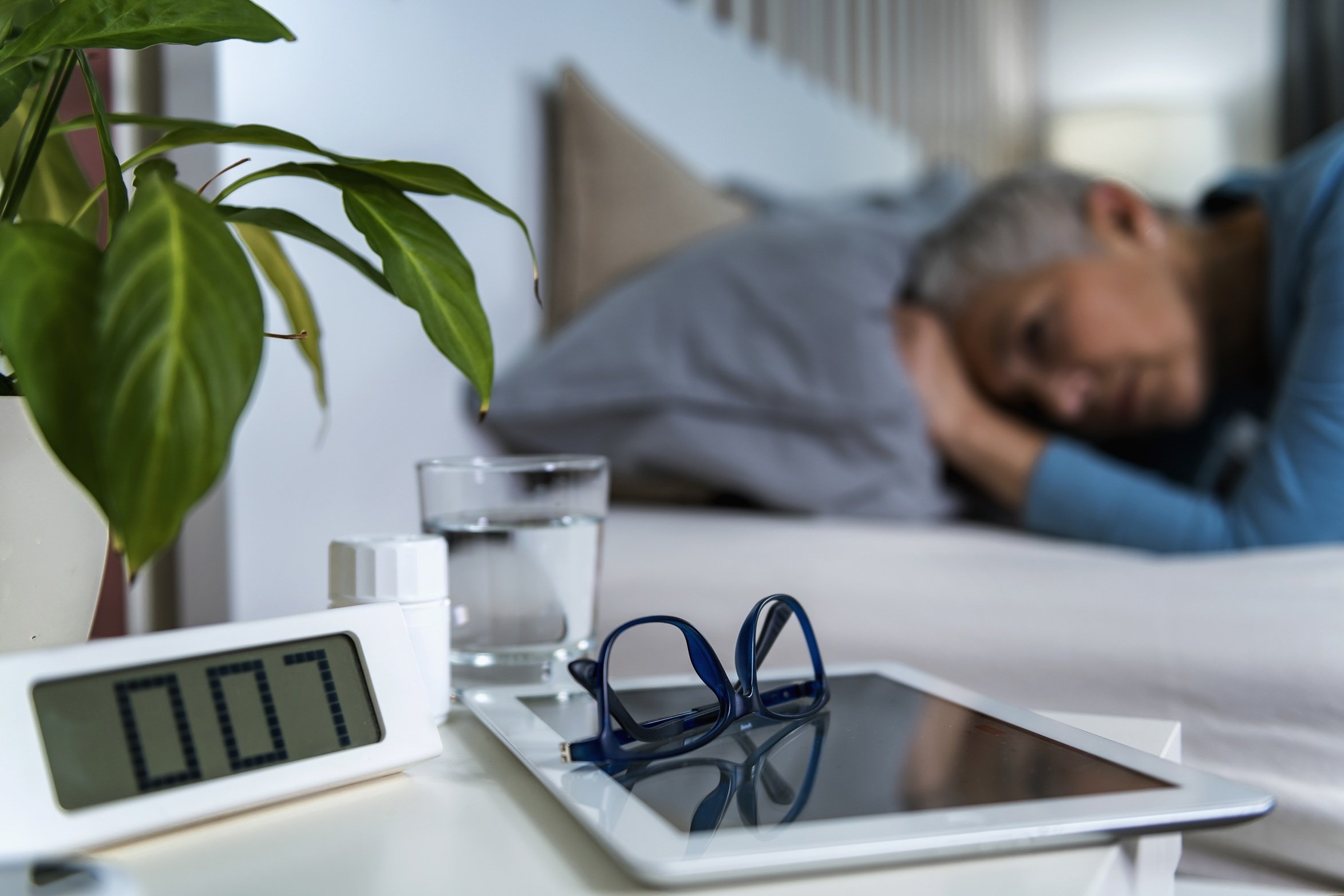 woman-lying-in-bed-with-tablet-and-clock-2026-01-05-06-09-46-utc